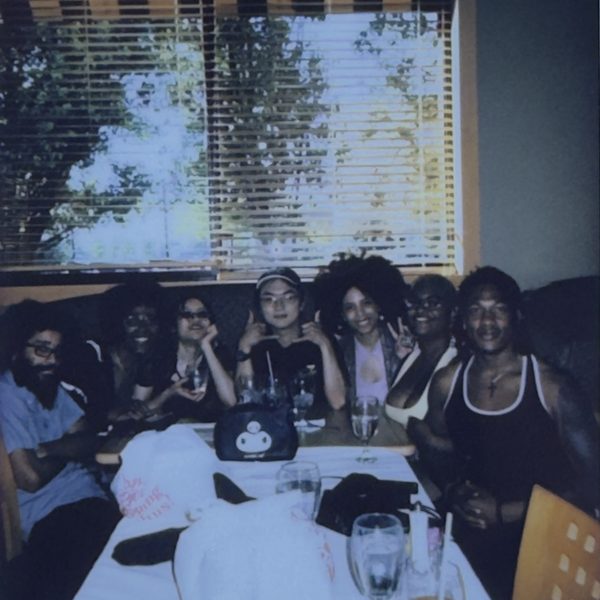 Friends squeezed into a restaurant booth, shot on instant film