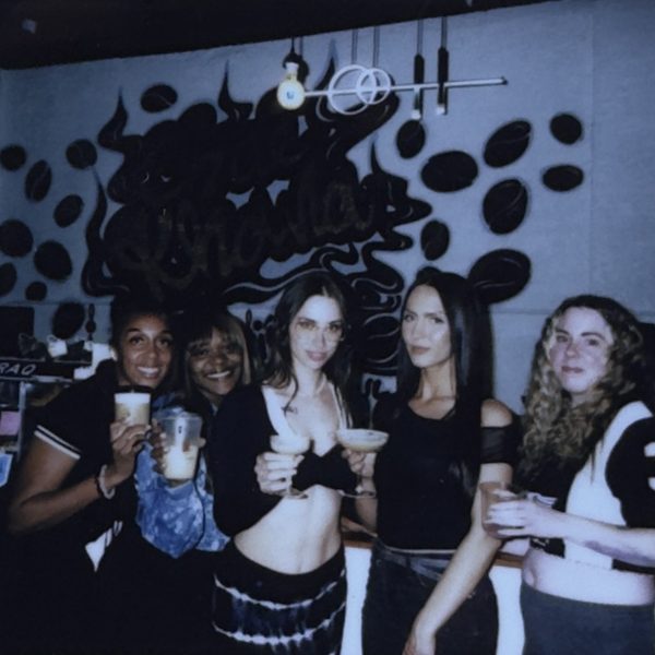 Friends raising their drinks at a bar, shot on instant film
